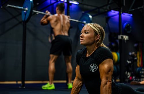 Coach watching an athlete perform a barbell overhead press